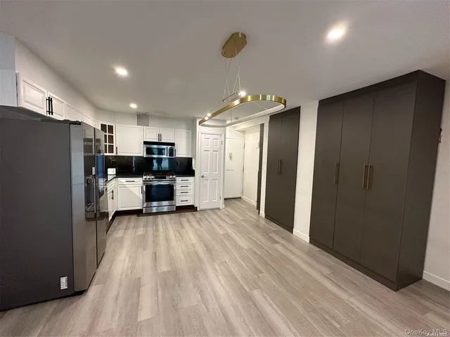 a view of a kitchen with a refrigerator and a fireplace