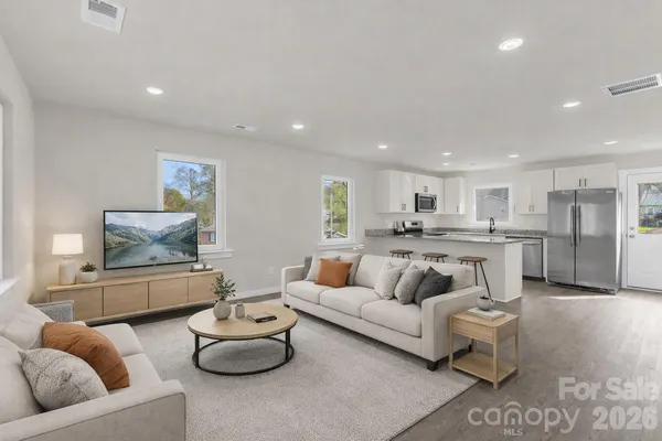 a living room with furniture and kitchen view