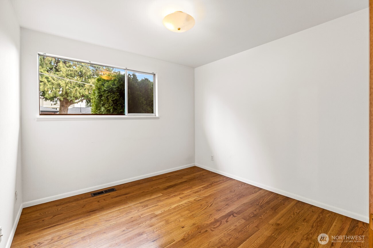 1006 North 36th Street Renton, WA 98056 - Photo 13 of 21 an empty room with wooden floor and windows