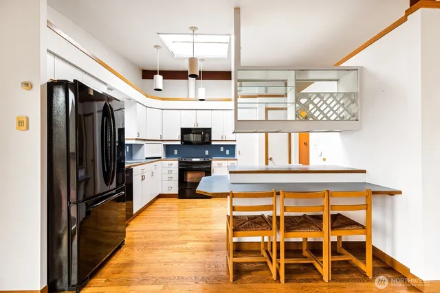a kitchen with kitchen island granite countertop a refrigerator and a stove top oven