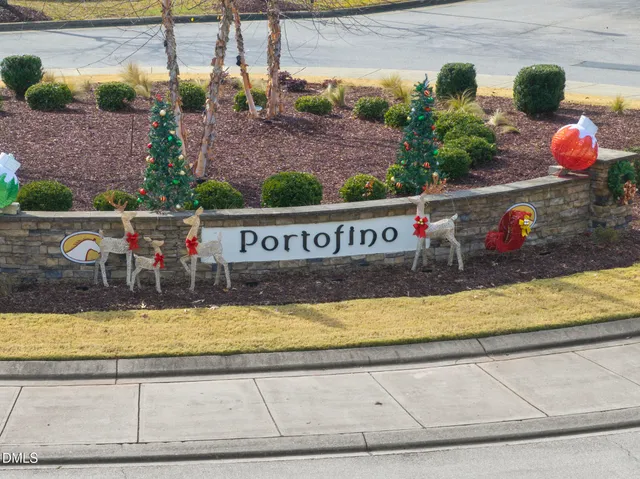 a front view of a house with a yard and potted plants