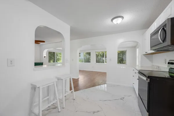 a kitchen with granite countertop white cabinets and stainless steel appliances