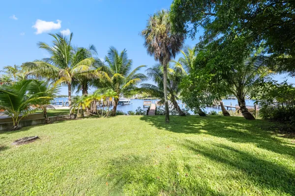 a view of a patio with couches table and chairs under an umbrella with wooden floor