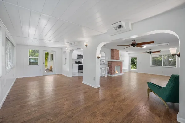 a view of an empty room with a window and wooden floor