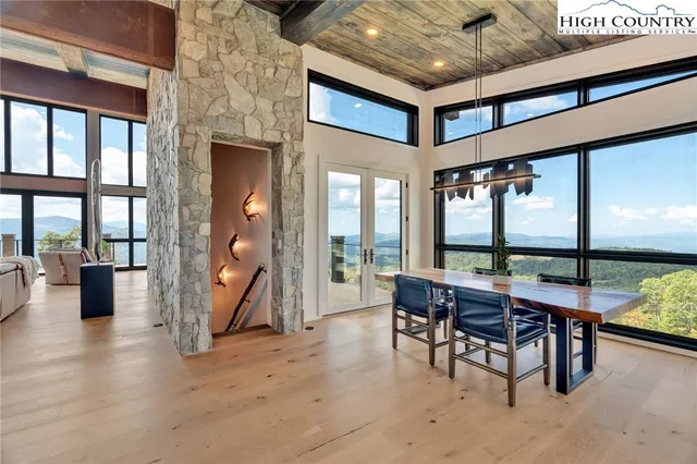 a dining room with furniture and a floor to ceiling window