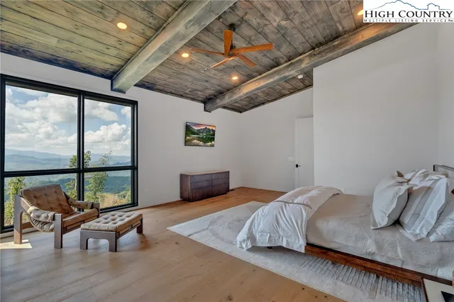 a bedroom with furniture and a large window