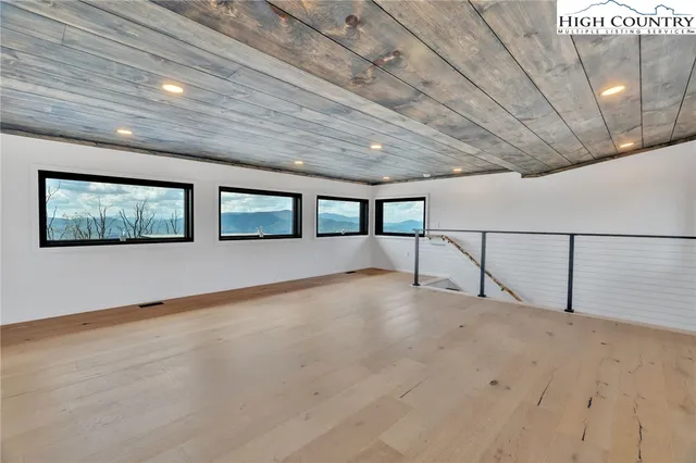 a view of balcony with wooden floor & fence