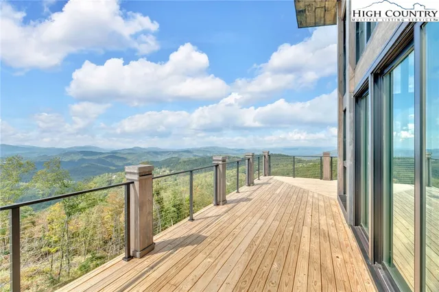 a view of a balcony with wooden floor & fence