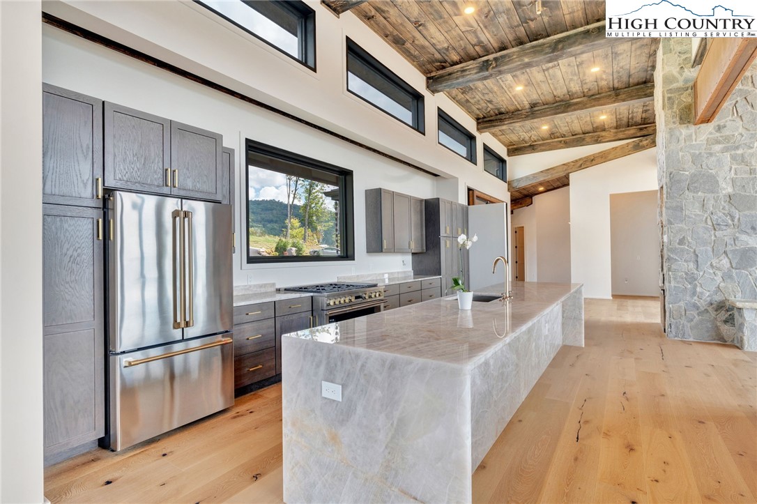 294 Silver Eagle Trail Banner Elk, NC 28604 - Photo 10 of 50 a kitchen with stainless steel appliances granite countertop a refrigerator a stove and a sink with wooden floor