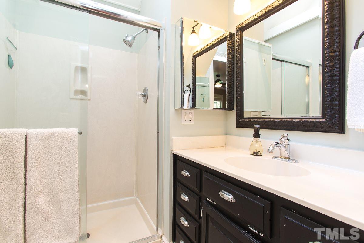 1715 Six Gables Road Durham, NC 27712 - Photo 15 of 25 The master bath has been updated with a very cool, classic look. Black cabinet, white countertops, and vintage-style beehive floor tiles. Love it! The vaulted ceiling and skylight make it feel light and airy in here.