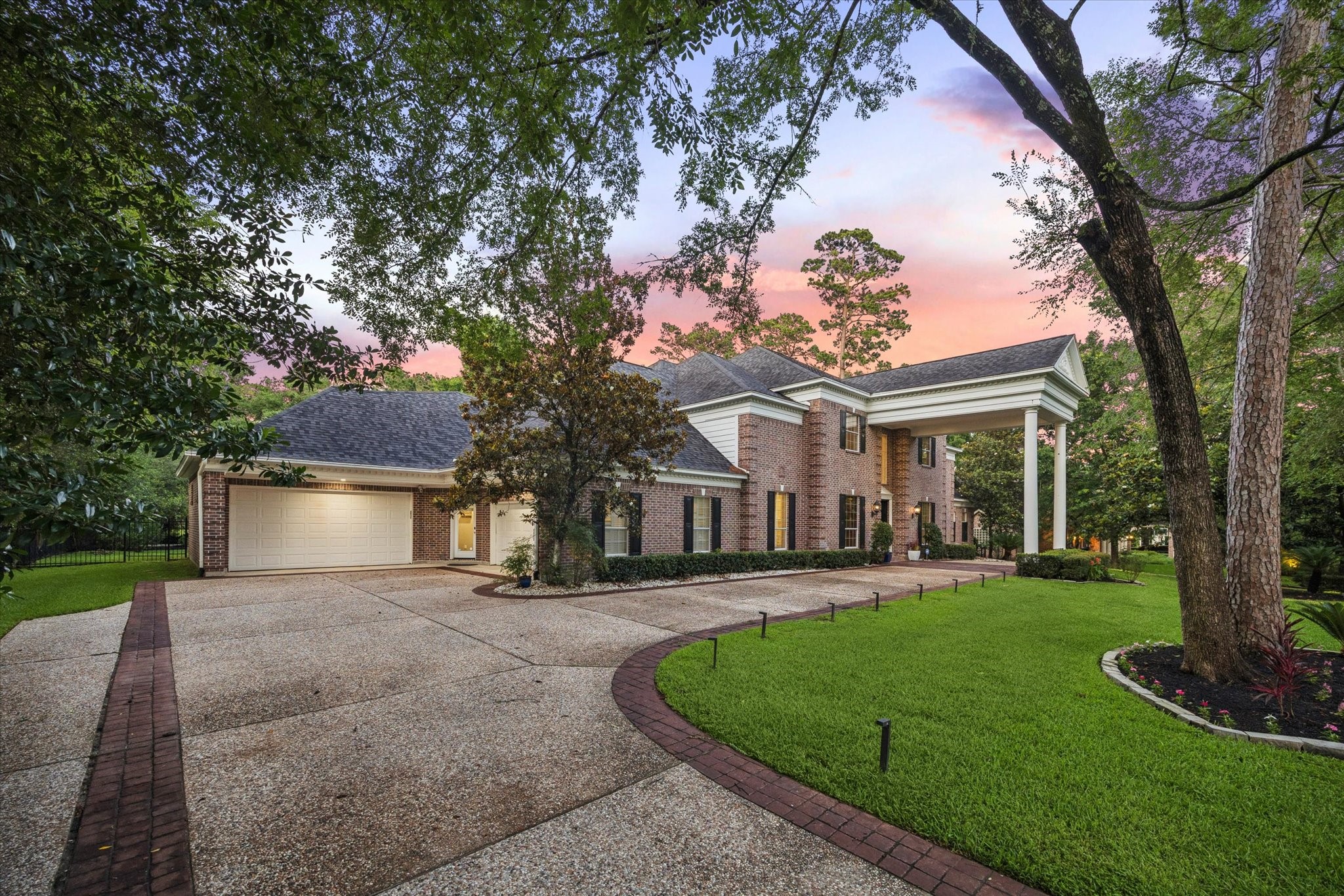 35 North Regent Oak Spring, TX 77381 - Photo 2 of 43 This image showcases the impressive circular driveway and grand approach to the residence, creating a truly grand arrival experience. Complementing the attached four-car garage, the expansive motor court provides abundant parking for guests and effortless day-to-day convenience. Thoughtfully designed to blend sophistication with functionality, this estate-style entrance sets the tone for the exceptional living experience that awaits within.