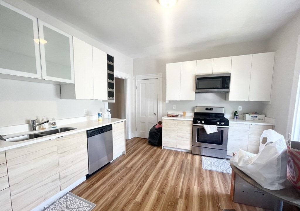 108 Buttonwood Street, Unit 1 Boston, MA 02125 - Photo 4 of 12 a kitchen with granite countertop a sink stove top oven and cabinets