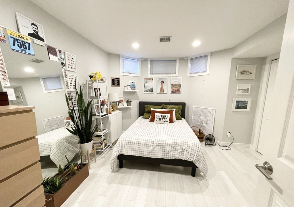 108 Buttonwood Street, Unit 1 Boston, MA 02125 - Photo 7 of 12 a spacious bedroom with a bed a mirror and desk