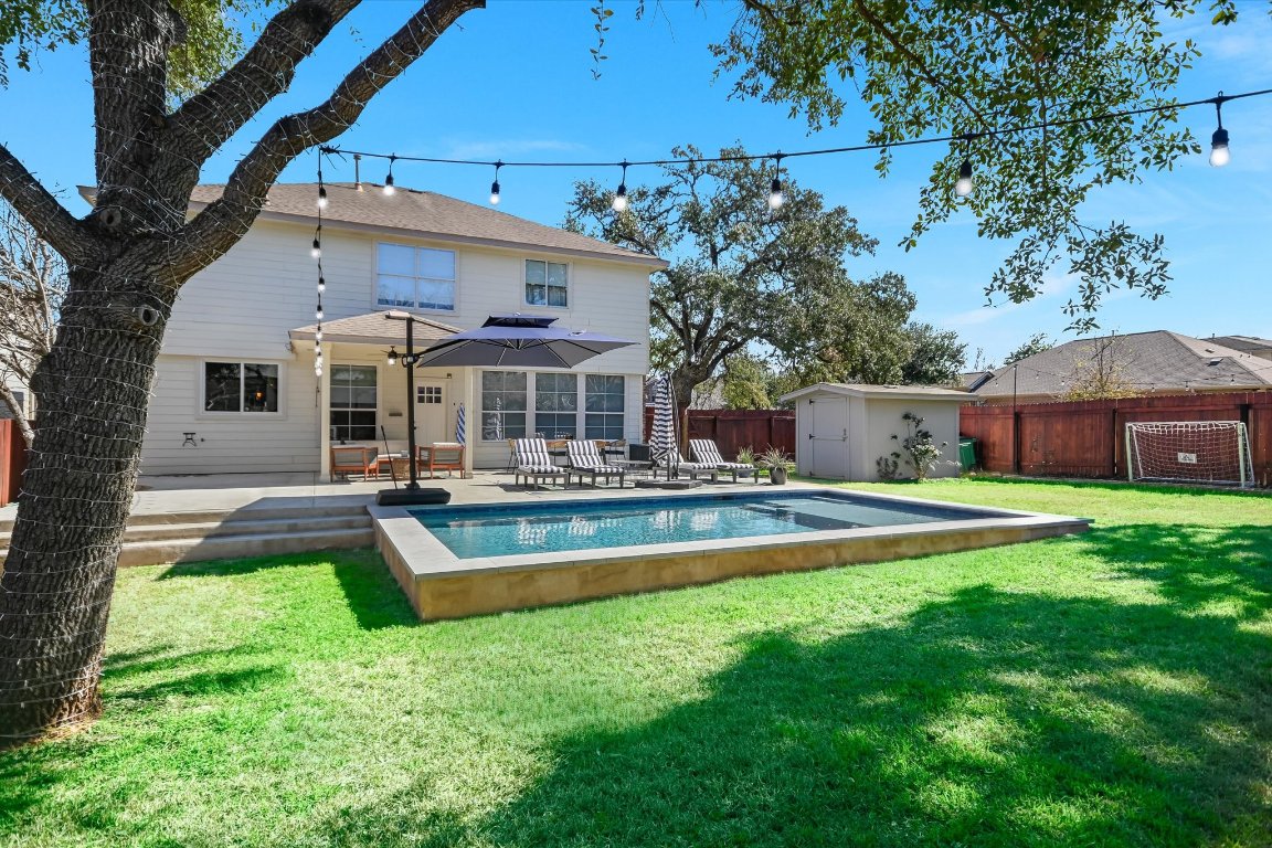 a view of a house with a yard patio and swimming pool
