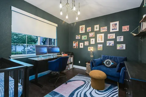 a living room with furniture a chandelier and a floor to ceiling window