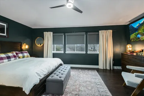 a bedroom with a bed dresser and a large window