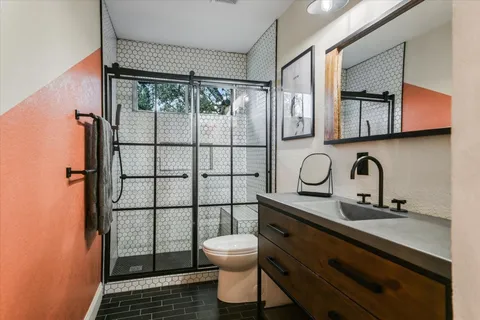 a bathroom with a sink a toilet and shower