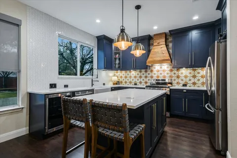 a kitchen with a stove a sink a center island and a window