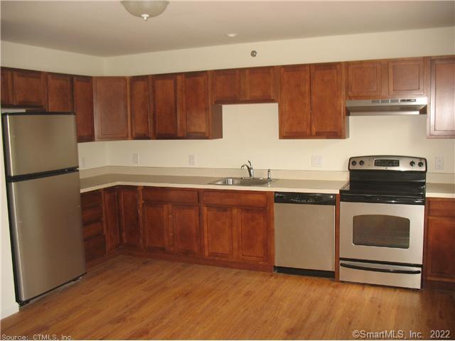 a kitchen with granite countertop a refrigerator sink and stove