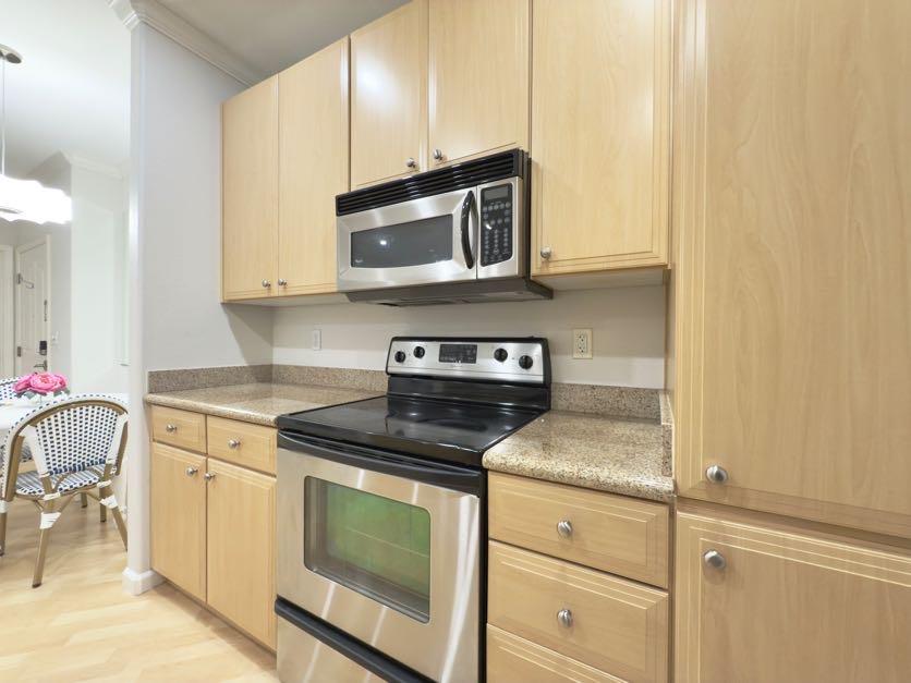 801 South Winchester Boulevard, Unit 4310 San Jose, CA 95128 - Photo 11 of 38 a kitchen with stainless steel appliances granite countertop a stove microwave and cabinets