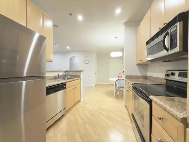 a kitchen with a sink a stove cabinets and a refrigerator