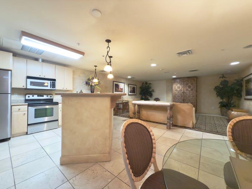 801 South Winchester Boulevard, Unit 4310 San Jose, CA 95128 - Photo 35 of 38 a kitchen with kitchen island a stove a sink a oven a dining table and chairs