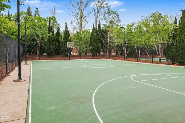 a view of a tennis ground with large trees