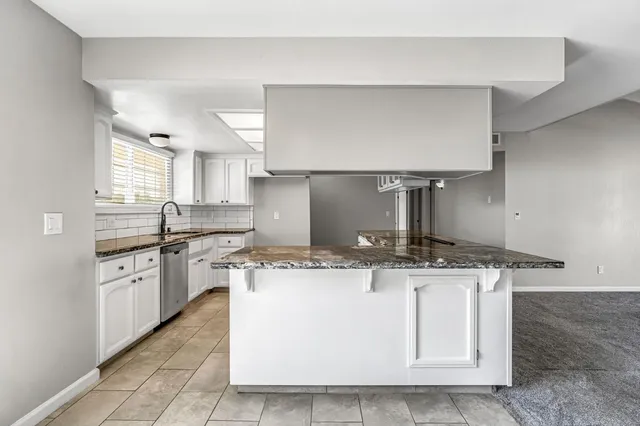 a kitchen with stainless steel appliances granite countertop a sink stove and cabinets