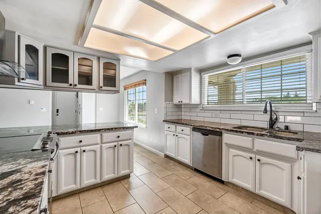 a kitchen with stainless steel appliances granite countertop a sink and cabinets