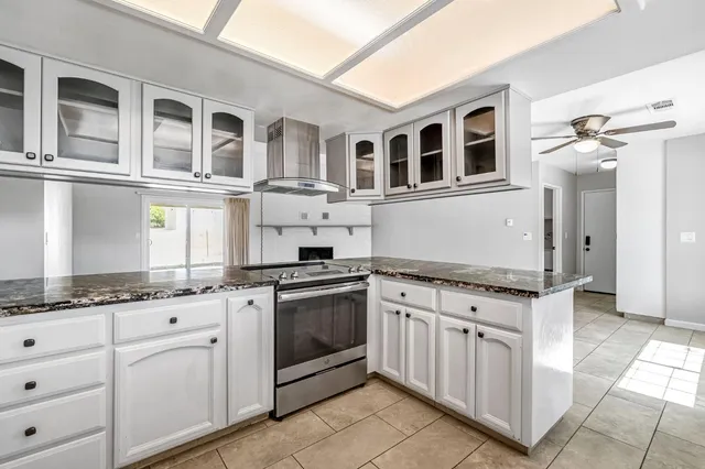 a kitchen with stainless steel appliances granite countertop a stove and a sink