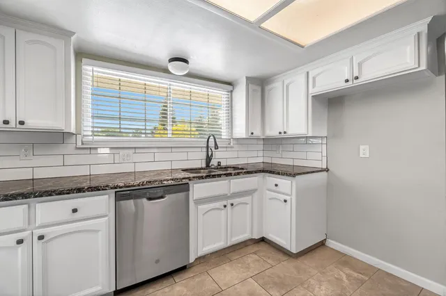 a kitchen with granite countertop a sink and cabinets