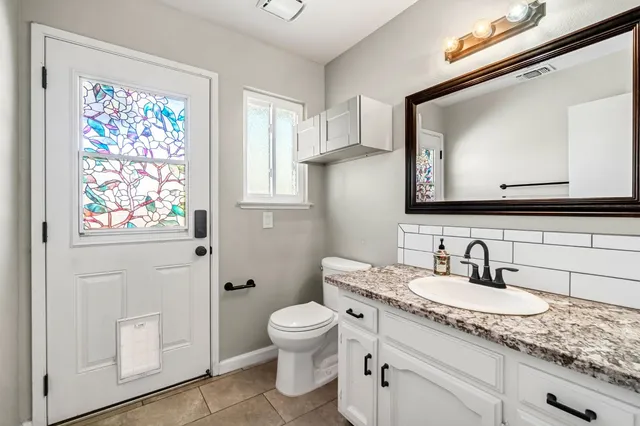 a bathroom with a granite countertop sink and a mirror