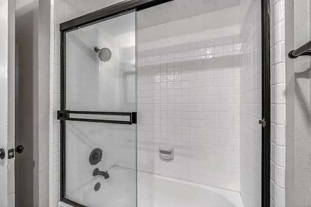 a view of a big room with windows and chandelier fan