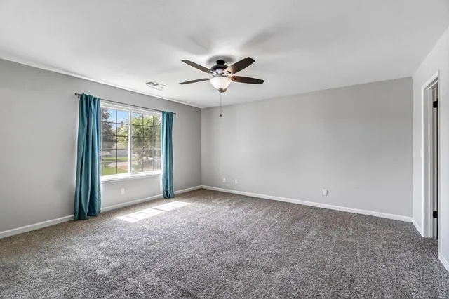 a view of an empty room and a ceiling fan
