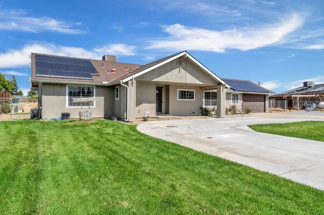 a front view of a house with a garden and yard