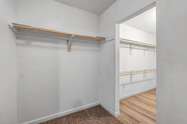 a view of a room with wooden floor and fan