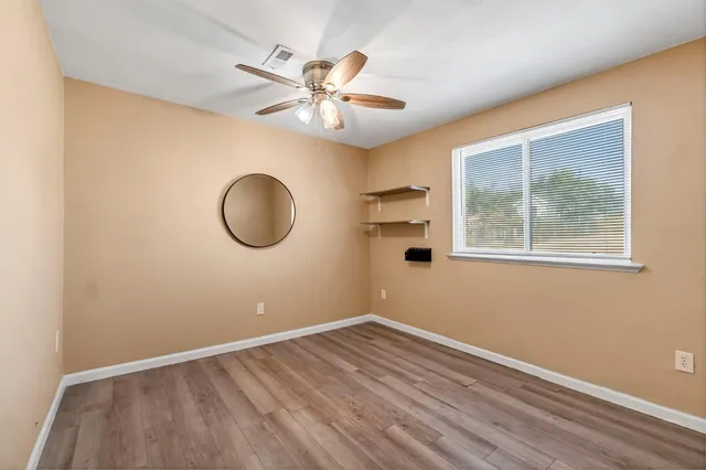 an empty room with closet and windows