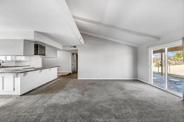 a large white kitchen with granite countertop a sink and dishwasher a stove with granite countertops