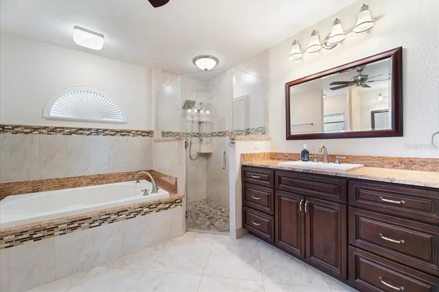 a view of a big room with windows and chandelier fan