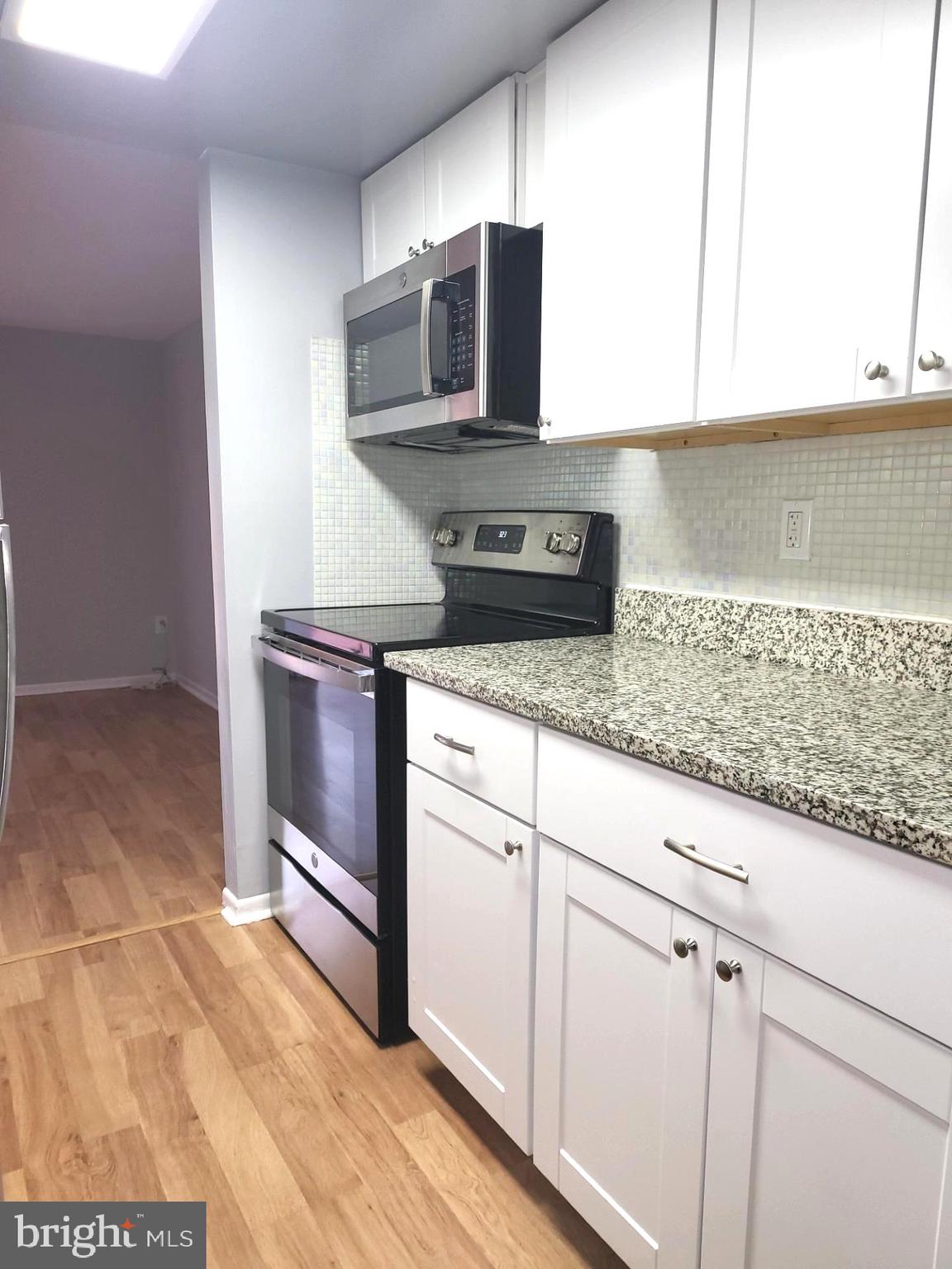 6556 Frietchie Row Columbia, MD 21045 - Photo 14 of 21 a kitchen with granite countertop a stove and a sink
