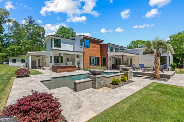a view of a house with backyard sitting area and swimming pool