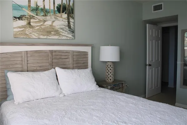 a bedroom with a bed and a painting on the wall