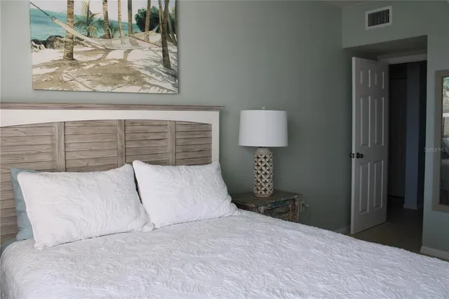 a bedroom with a bed and a painting on the wall