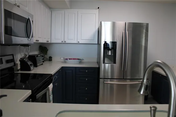a kitchen with stainless steel appliances granite countertop a refrigerator and a stove top oven