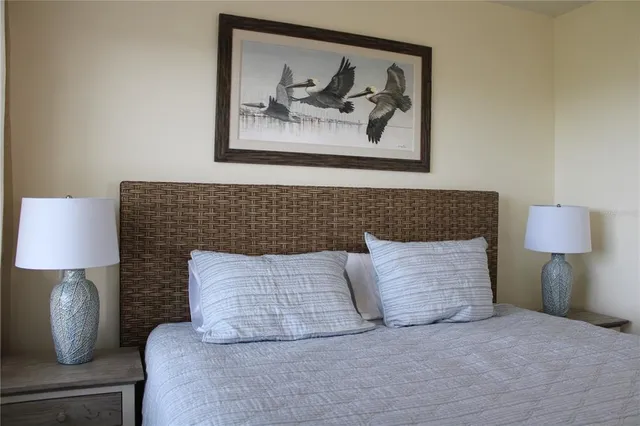 a bedroom with a bed and a lamp on the dresser