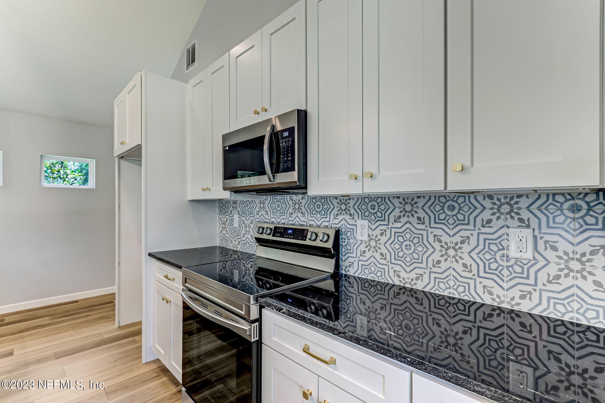 45115 South Mickler Street Callahan, FL 32011 - Photo 12 of 24 a kitchen with granite countertop white cabinets stainless steel appliances and a counter space