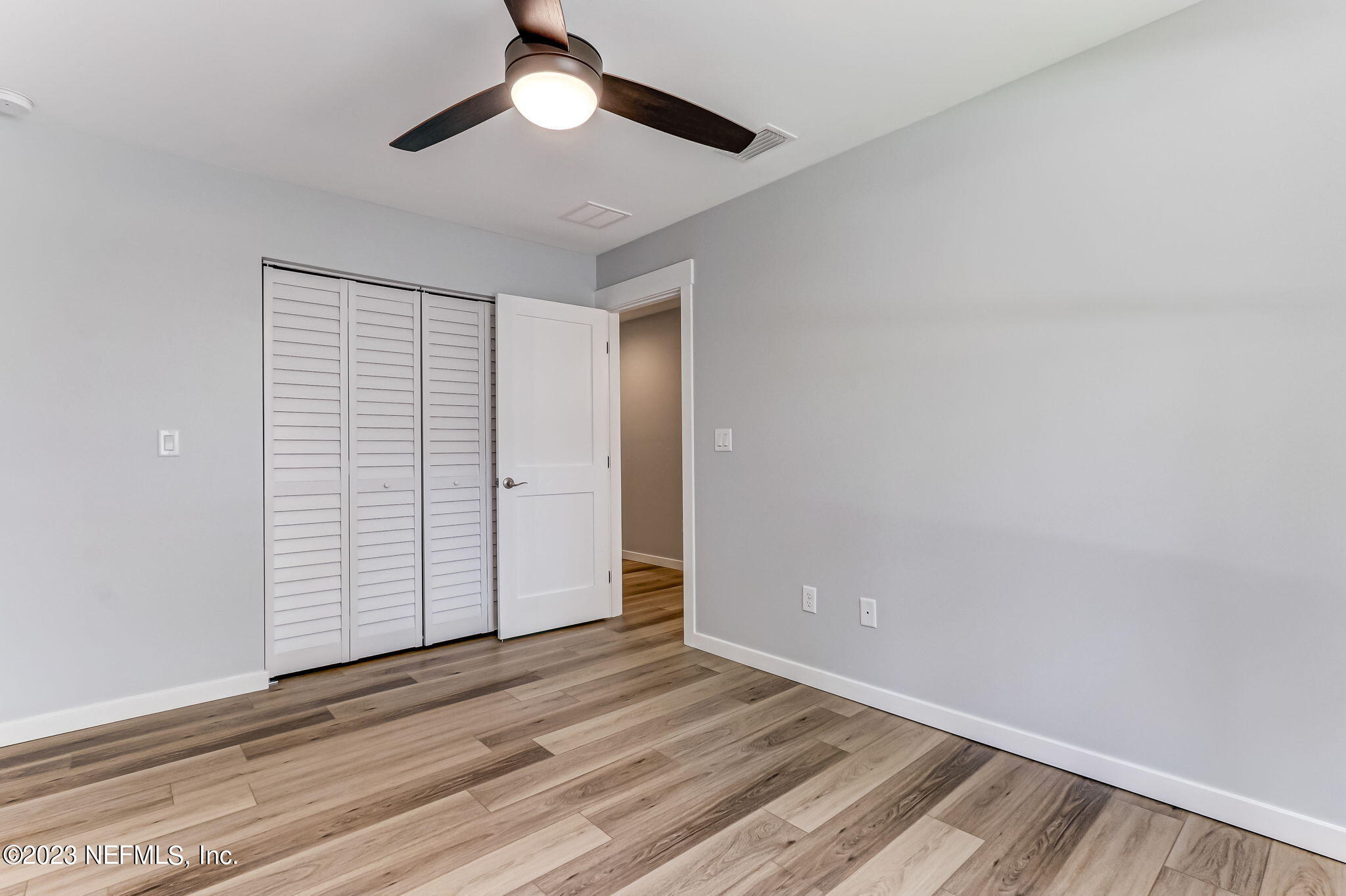 45115 South Mickler Street Callahan, FL 32011 - Photo 21 of 24 an empty room with wooden floor chandelier fan and closet in a room