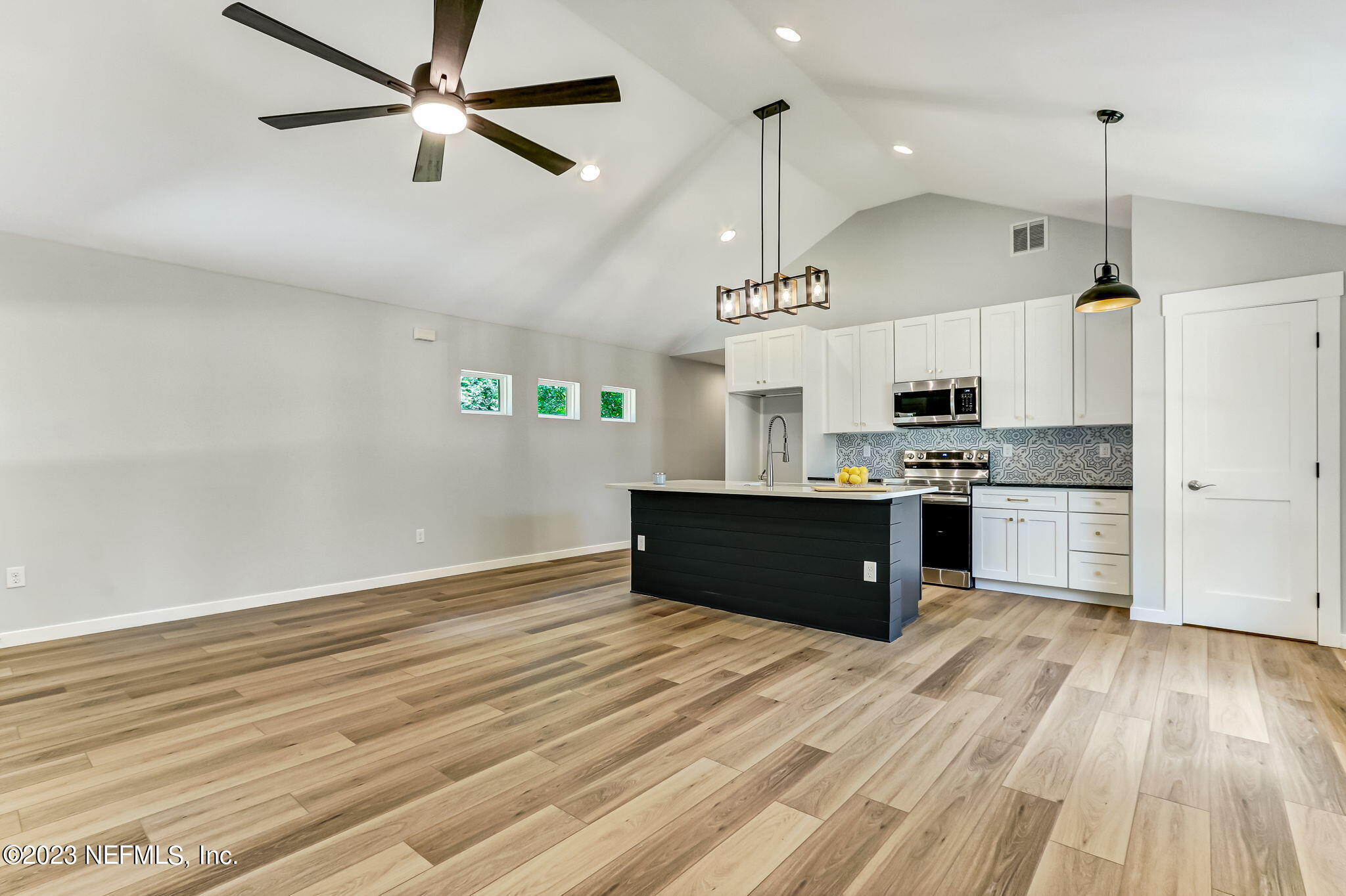 45115 South Mickler Street Callahan, FL 32011 - Photo 9 of 24 a kitchen with stainless steel appliances kitchen island a refrigerator and a wooden floors