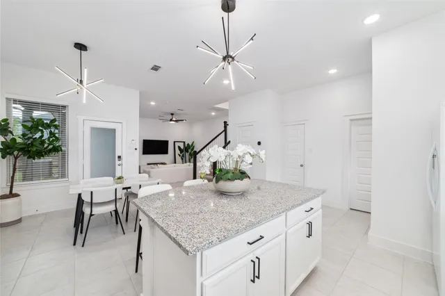 a kitchen with white cabinets and a window