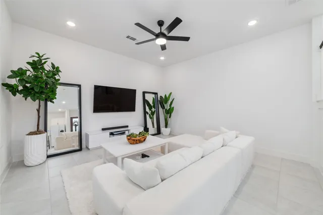 a living room with furniture and a potted plant
